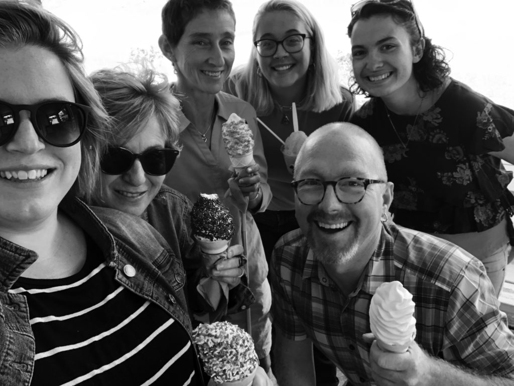 The staff smile up at the camera, each one holding an ice cream cone or frozen treat, in this selfie-style portrait. From Left: Katie Miller, Peggy Rainville, Heidi Swevens, Rachel Paskavitz, Scott Robbins, and Emily Schulze.