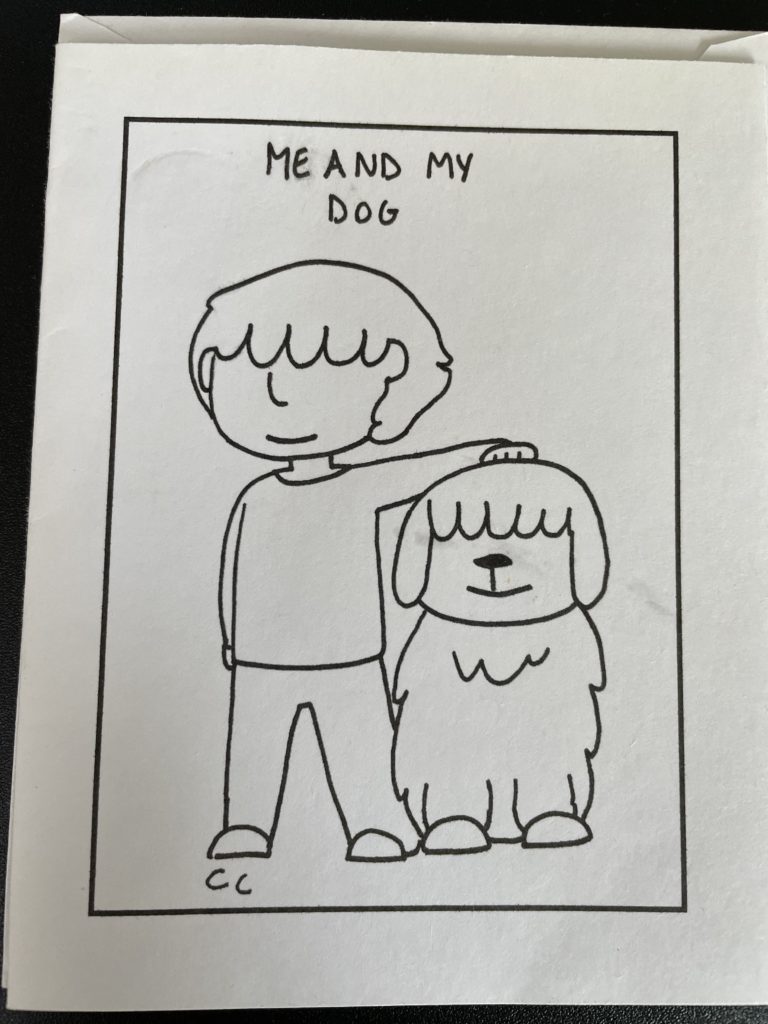 A vertical line drawing, black marker on white paper. Inside a drawn rectangle frame, at top, in all capital letters, handwritten, it says, “ME AND MY DOG.” The main image is of a person standing next to a dog, with their hand on the dog’s head. Both human and dog have shaggy bangs that cover their eyes.